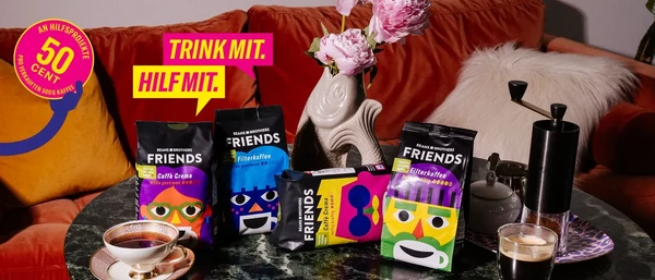 Bunte FRIENDS-Kaffeepackungen auf Wohnzimmertisch