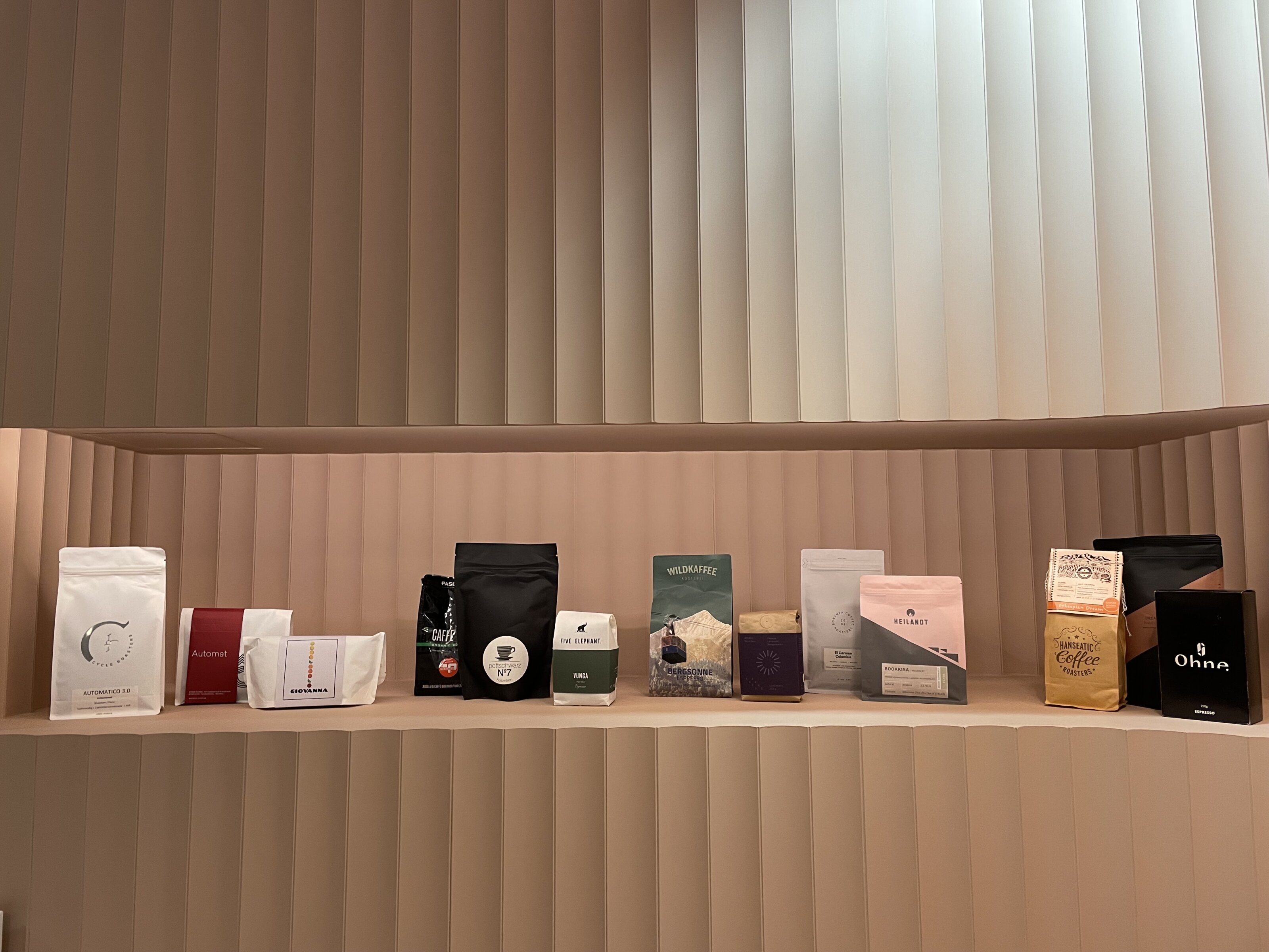 Reihe bunter Kaffeepackungen auf hellen Regalen