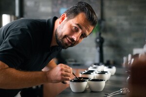 Link: Großansicht des Bildes - Bildinhalt: Person verkostet Kaffee aus mehreren Tassen