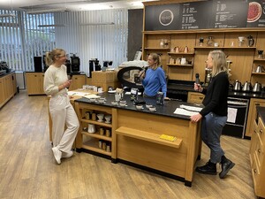 Link: Großansicht des Bildes - Bildinhalt: Drei Frauen mit Mikrofonen in moderner Kaffeebar