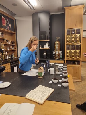Link: Großansicht des Bildes - Bildinhalt: Person leitet Kaffeeverkostung mit mehreren Tassen
