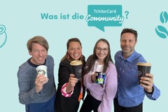 Vier Personen halten Kaffeebecher hoch