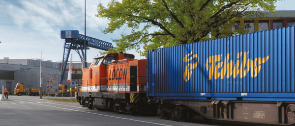 Güterzug mit blauem Tchibo-Container im Industriegebiet