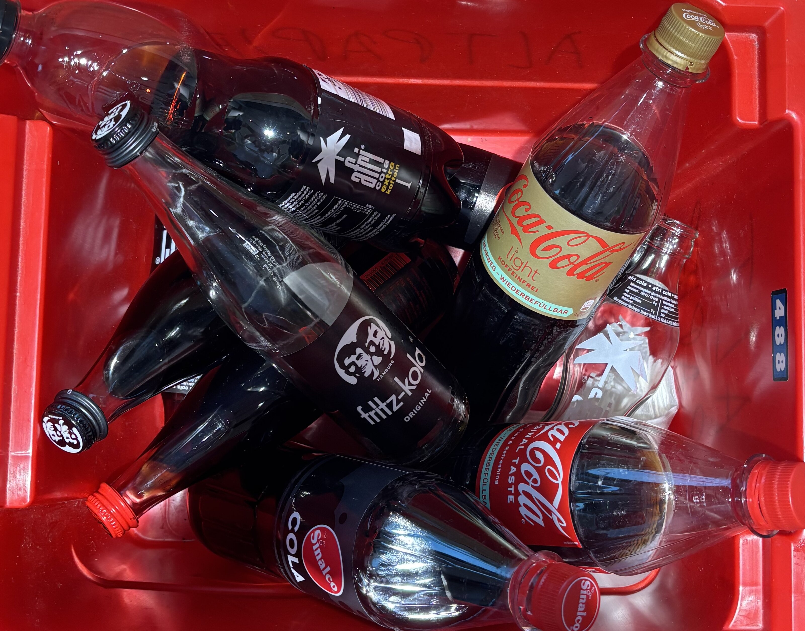 Mehrere Cola-Flaschen in roter Getränkekiste