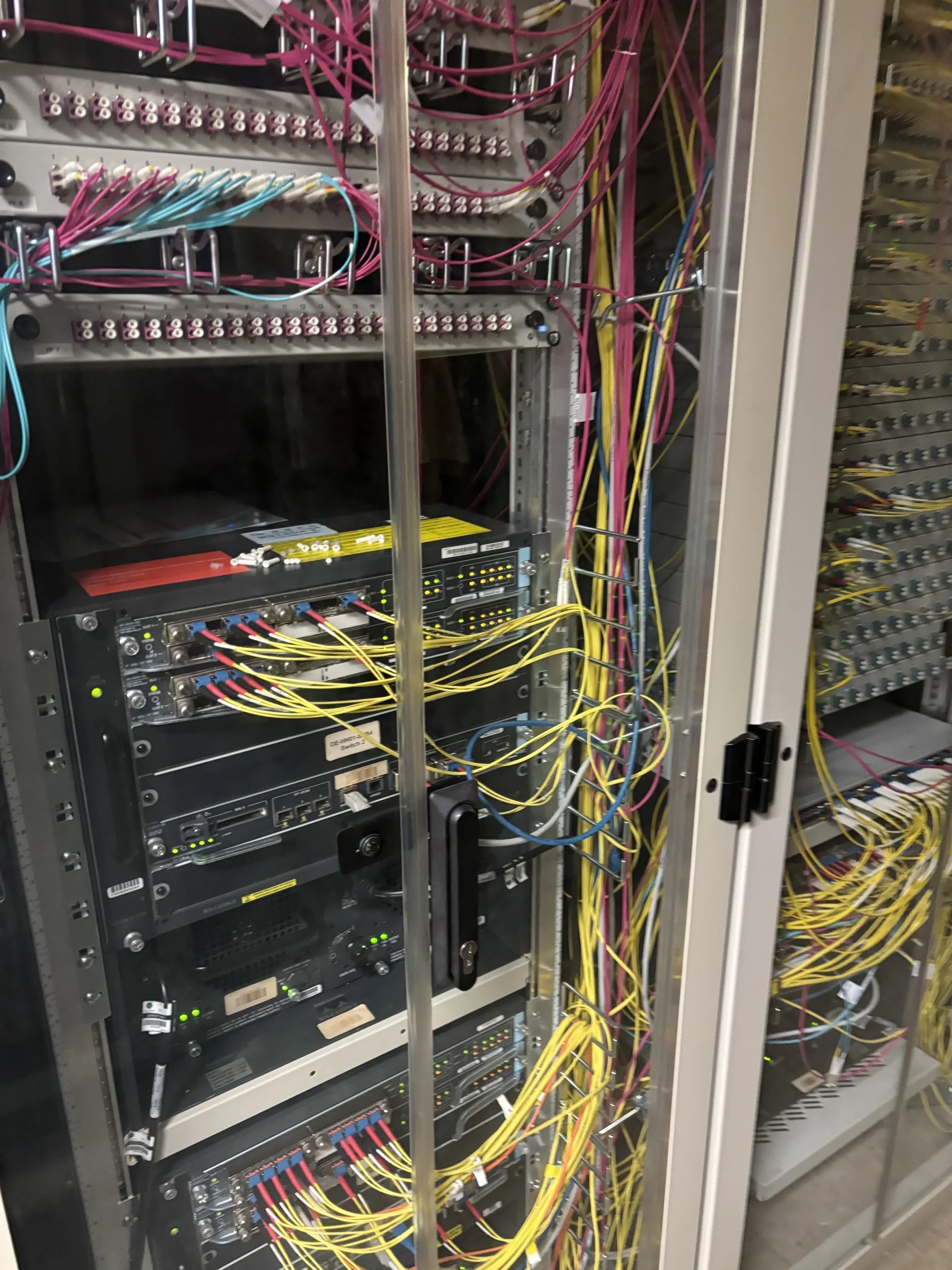 Serverrack mit vielen bunten Netzwerkkabeln