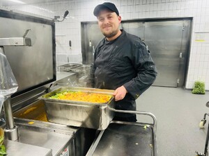 Link: Großansicht des Bildes - Bildinhalt: Koch in Großküche mit großer Gemüseauflaufform