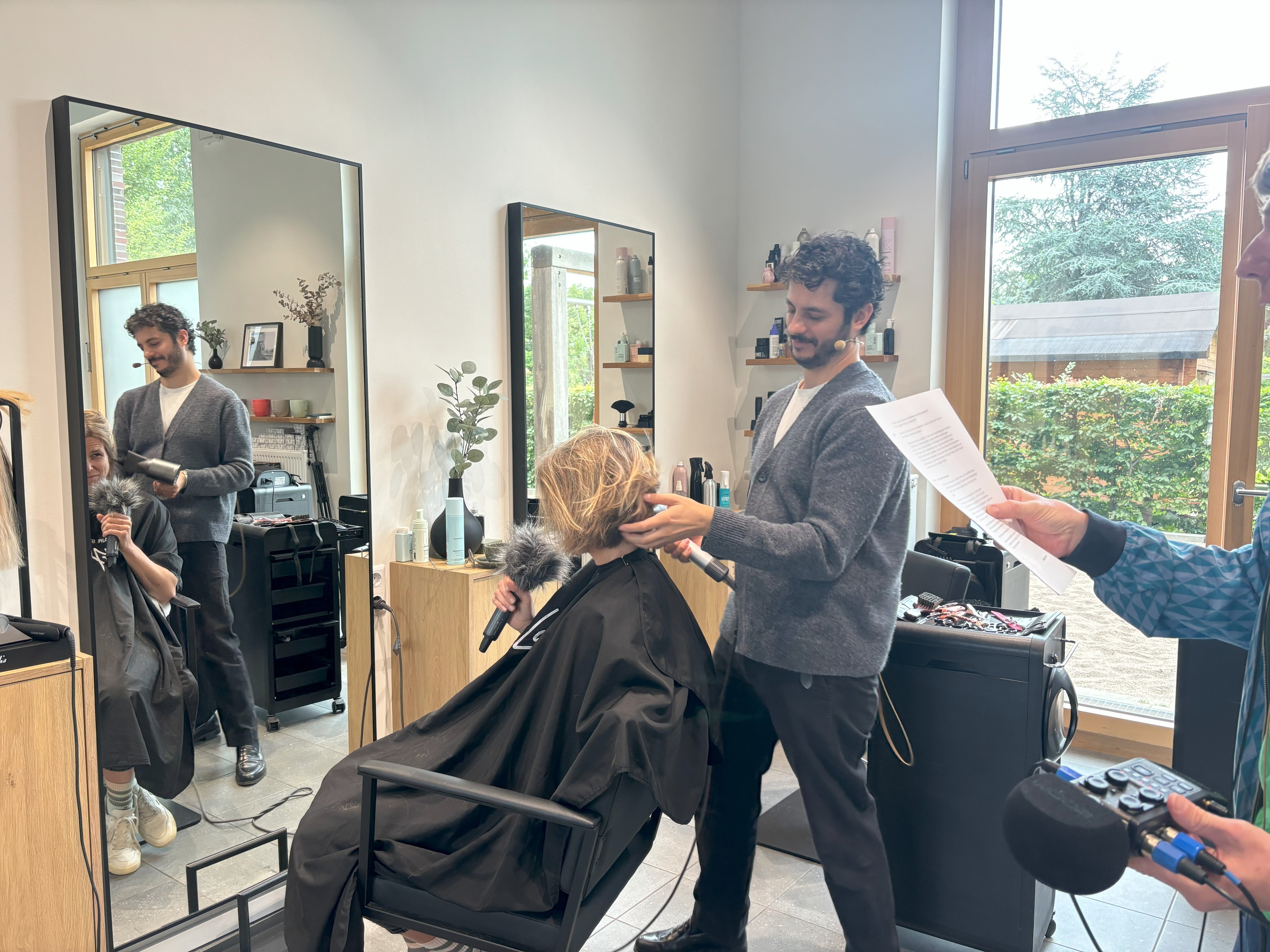 Friseur schneidet Haare, Person mit Mikrofon