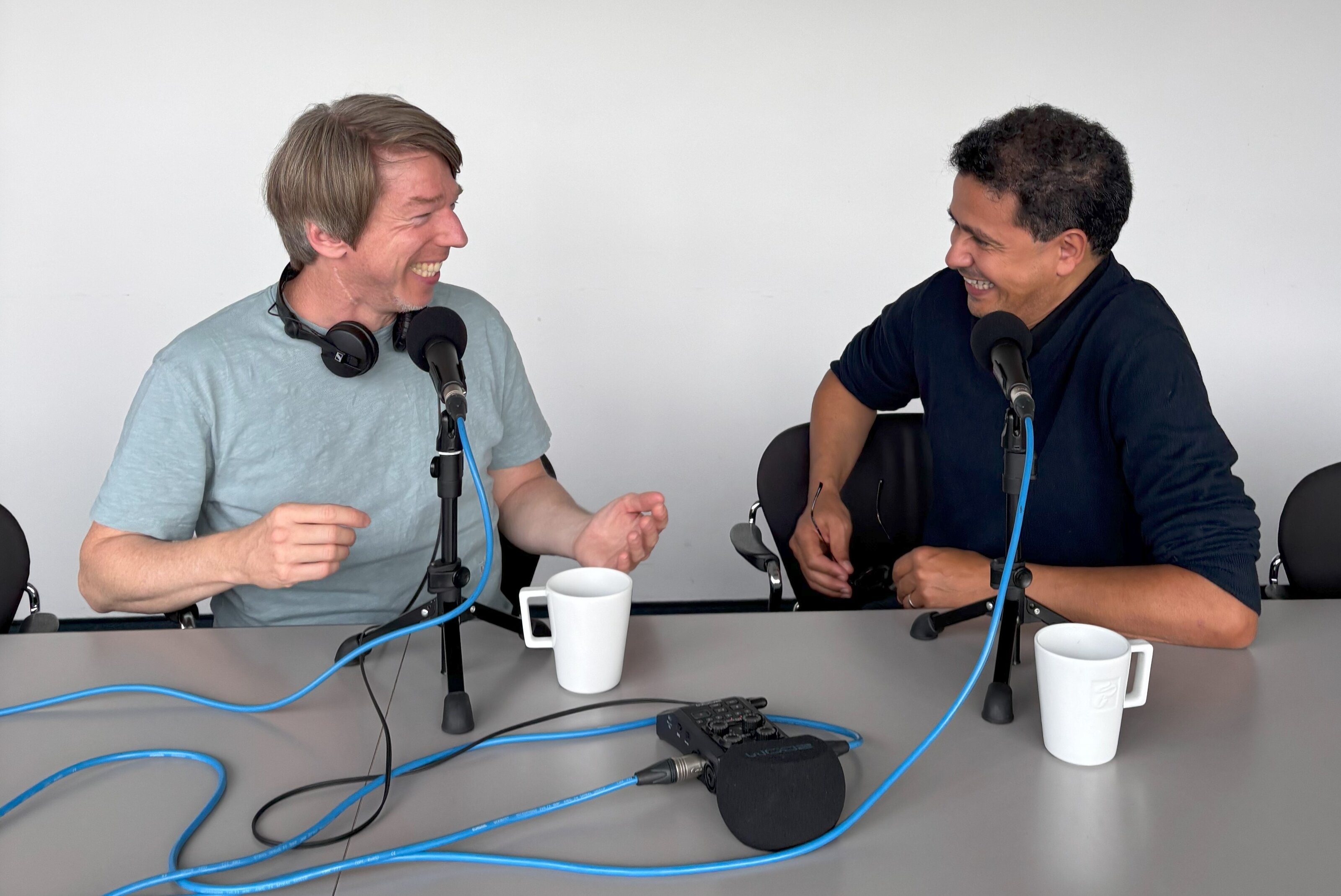 Zwei Personen beim Podcast-Gespräch am Tisch