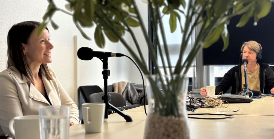 Zwei Personen nehmen Podcast an Tisch auf