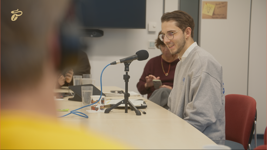 Personen am Konferenztisch mit Mikrofon