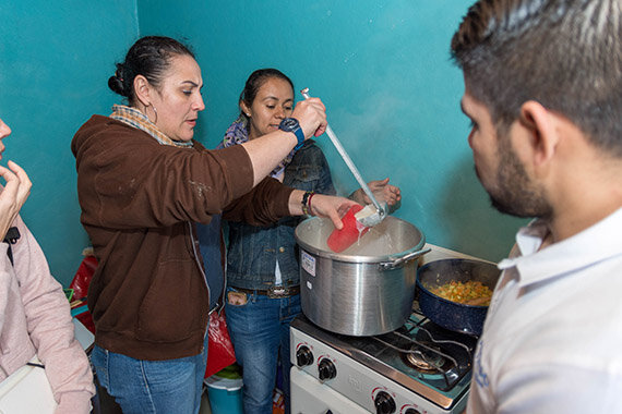Menschen kochen gemeinsam an einem Herd