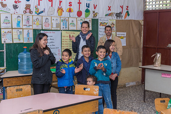 Gruppe von Kindern und Erwachsenen im Klassenraum