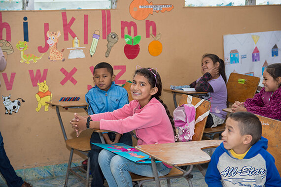 Kinder sitzen im bunt dekorierten Klassenzimmer