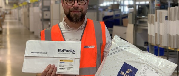 Mitarbeiter im Lager mit RePack- und Tchibo-Paket