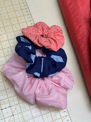 Link: Großansicht des Bildes - Bildinhalt: Drei bunte Stoff-Scrunchies auf Nähtisch