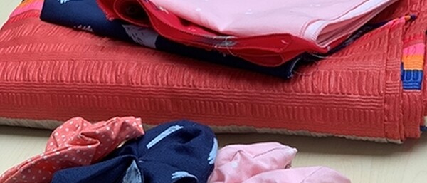 Gefaltete bunte Stoffe und Stoffreste auf Tisch