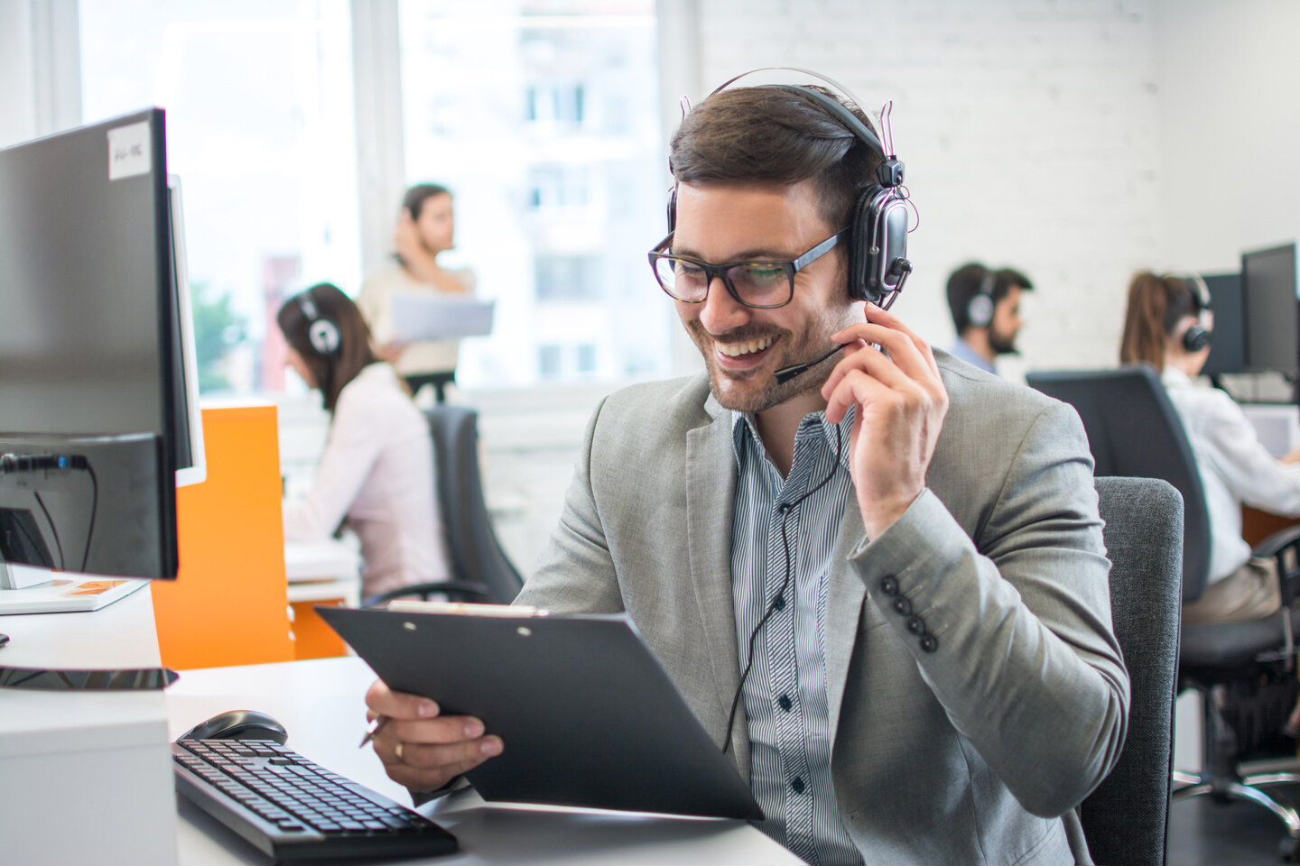 Mitarbeiter mit Headset im Großraumbüro