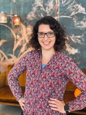 Person mit Locken, Hände in die Hüften gestützt