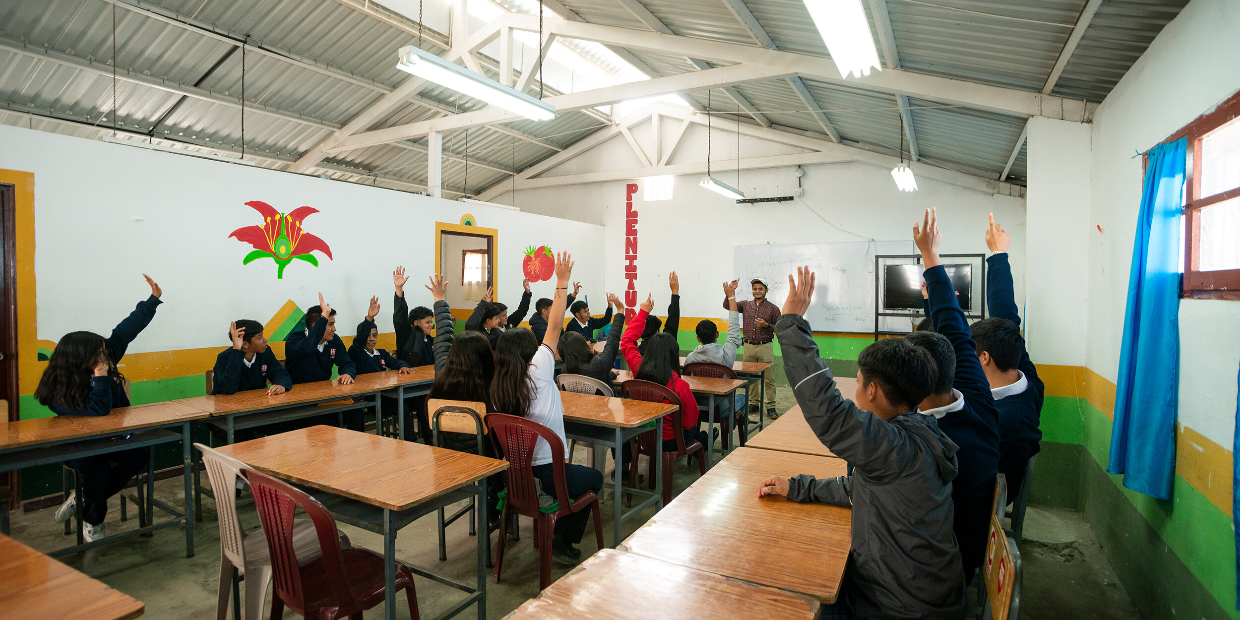 Schüler heben im Klassenzimmer die Hände