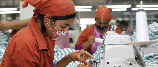 Frau näht an Industrienähmaschine in Fabrik