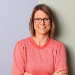 Lächelnde Frau mit Brille in rosafarbenem Pullover