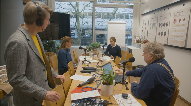 Four people recording a podcast around a table