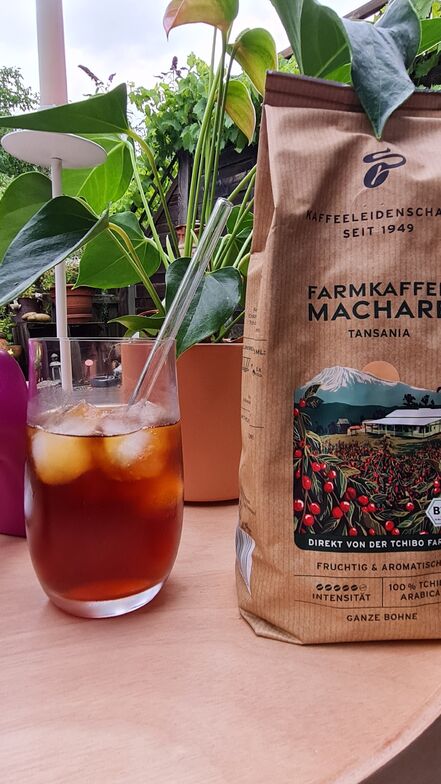 Iced coffee and Tchibo Farmkaffee bag outdoors