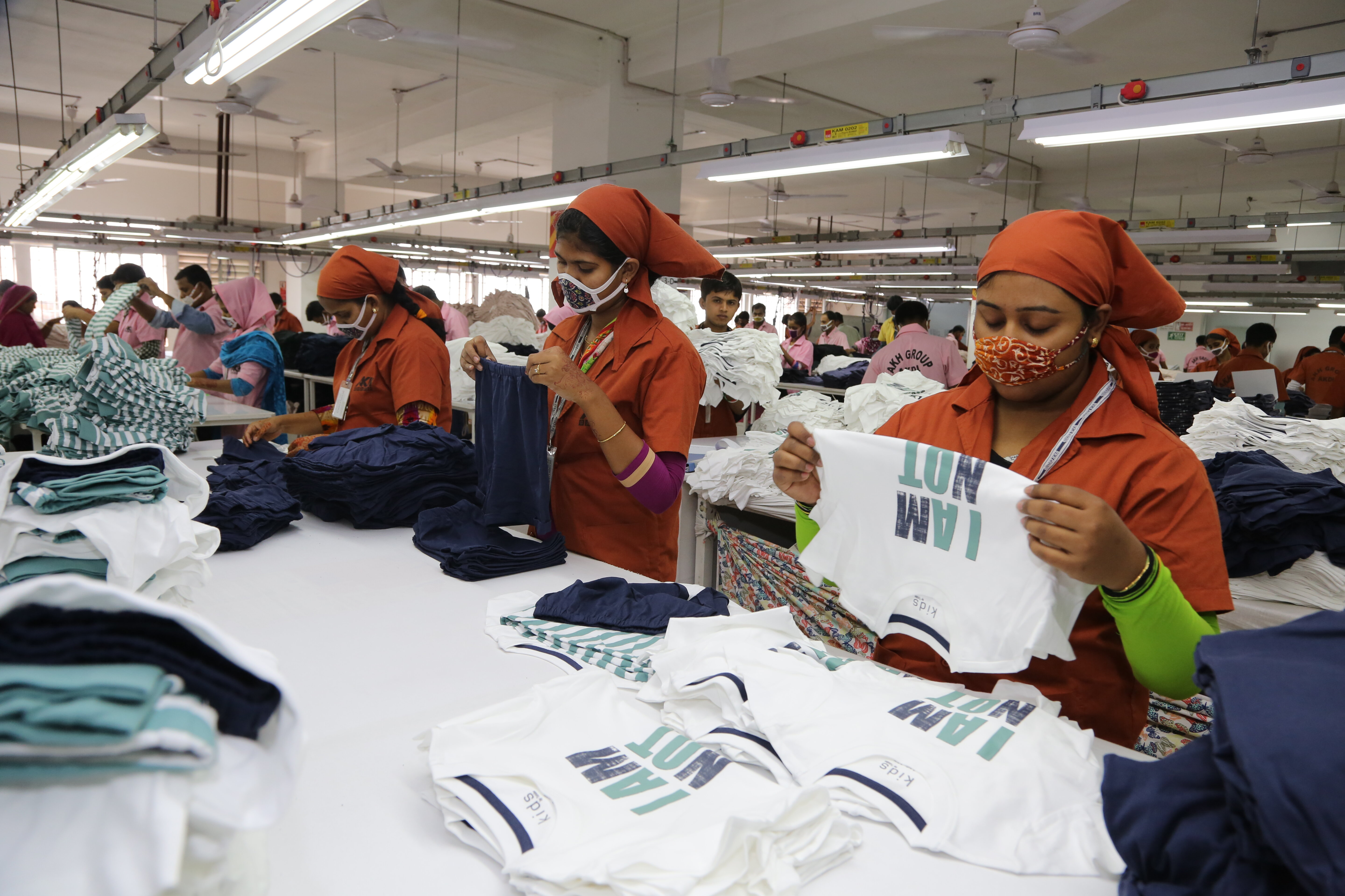 Garment workers sorting and folding clothes in factory