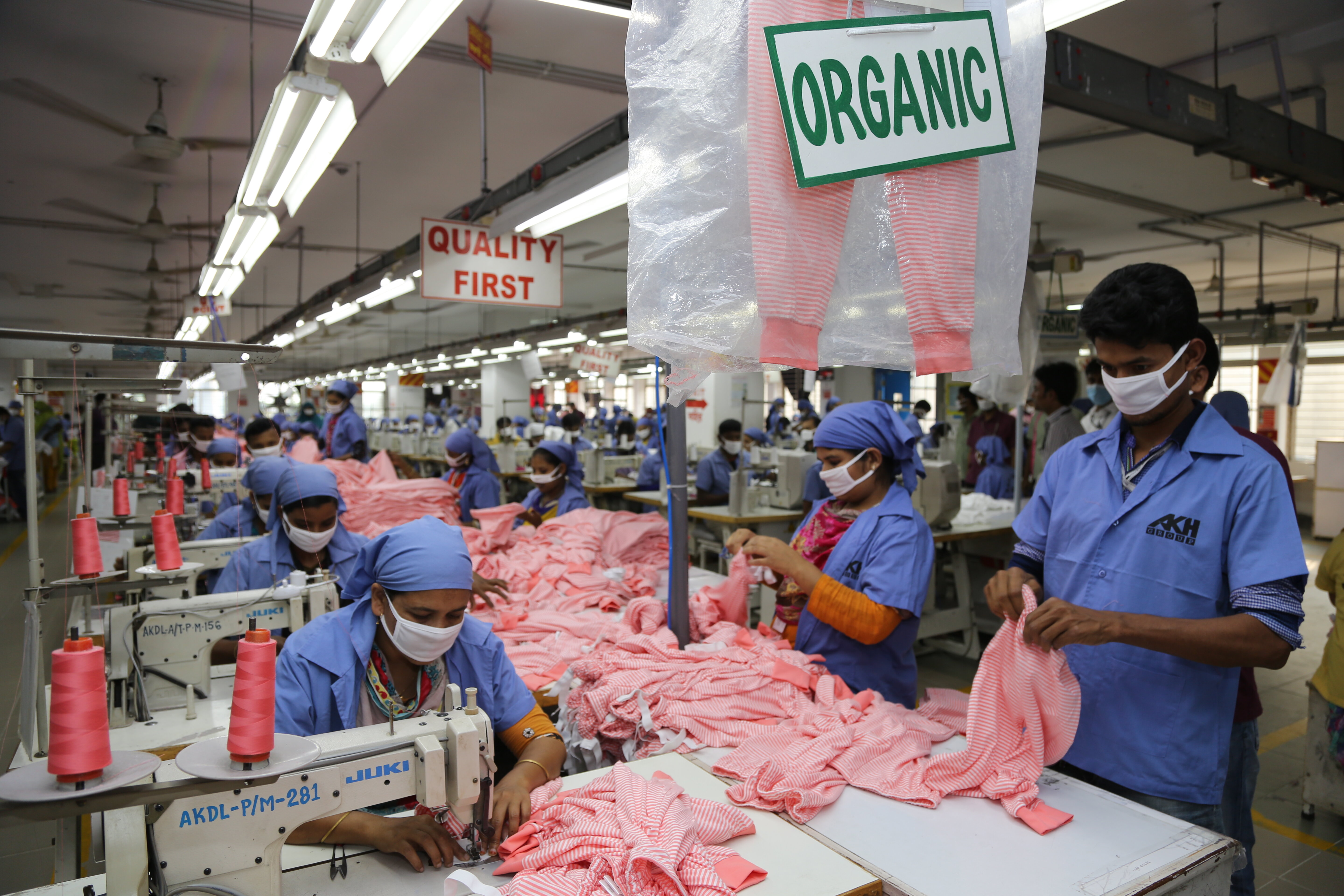 Garment workers sewing pink organic clothing