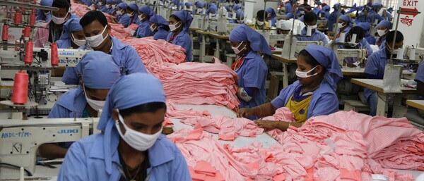 Garment factory workers sewing pink striped clothes